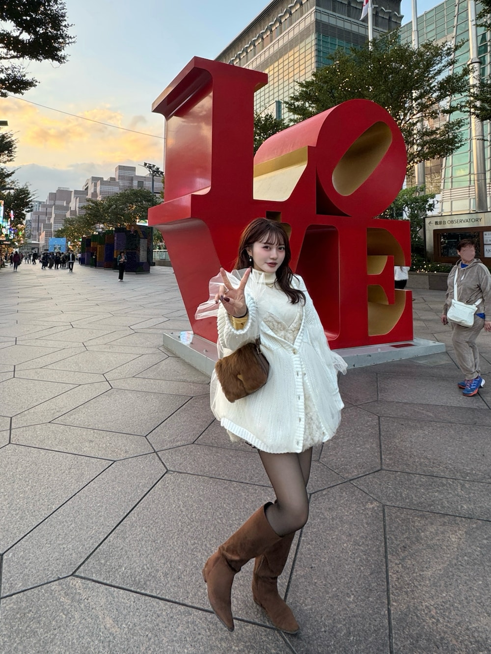 ブラウン系のブーツ、ホワイト系のカーディガン/ボレロを着用したレディースの冬コーディネートの5枚目の写真