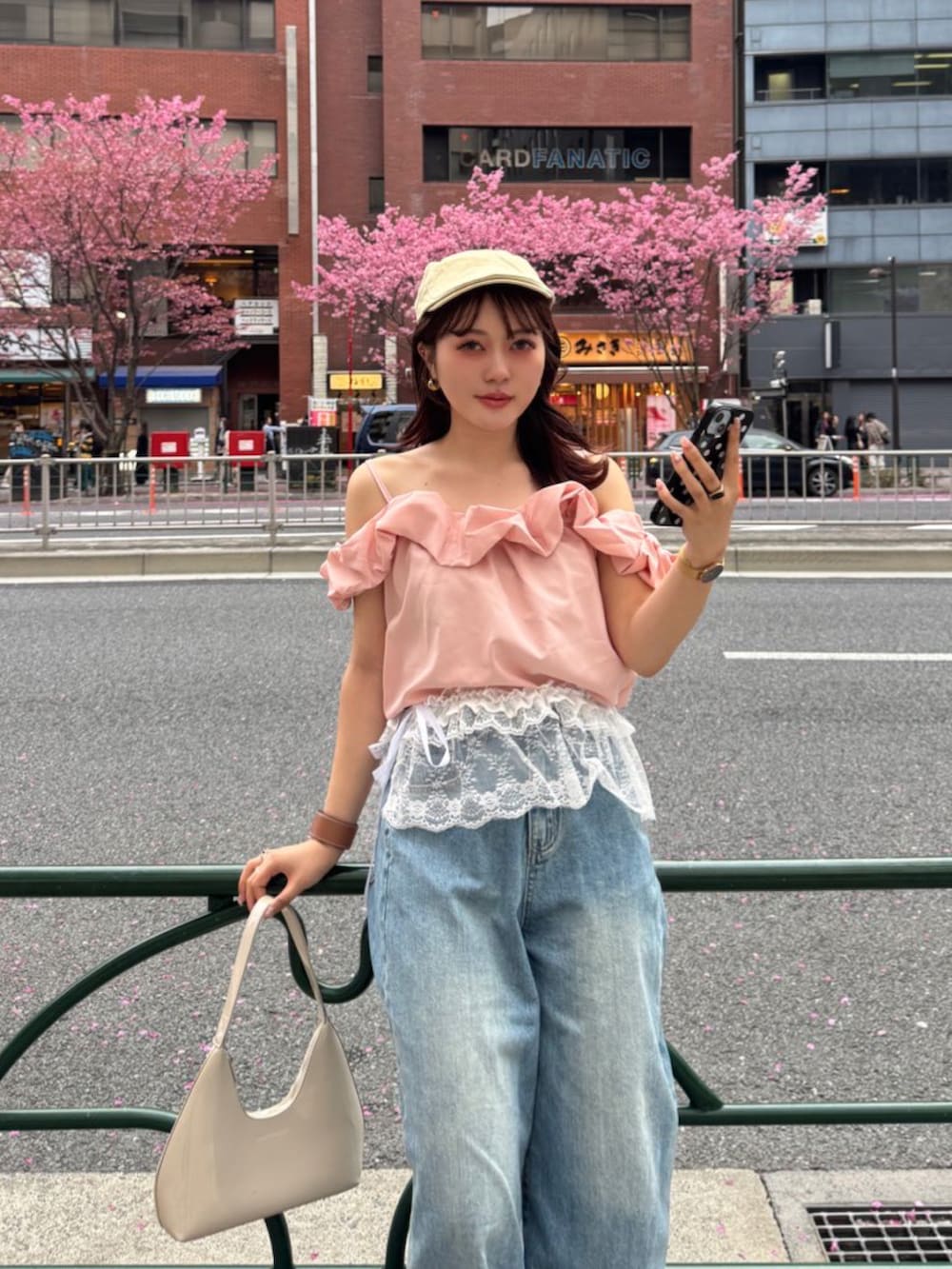 ベージュ系のハンドバッグ、ピンク系のTシャツ/カットソー、ホワイト系のスカートを着用したレディースの春コーディネートの5枚目の写真