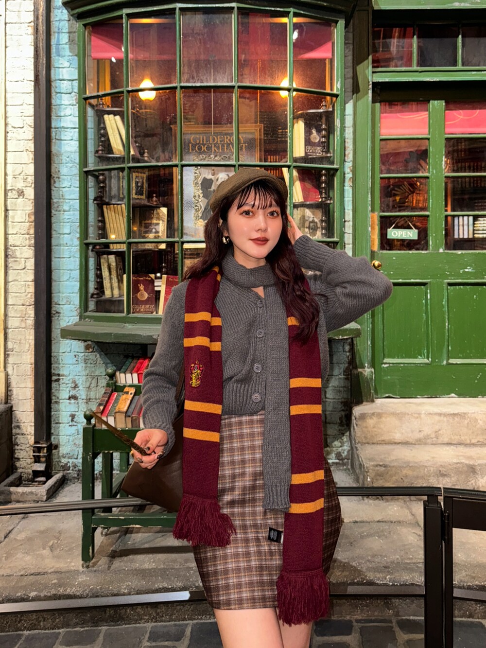 グレー系のニット/セーター、ブラウン系のスカートを着用したレディースの秋コーディネートの2枚目の写真