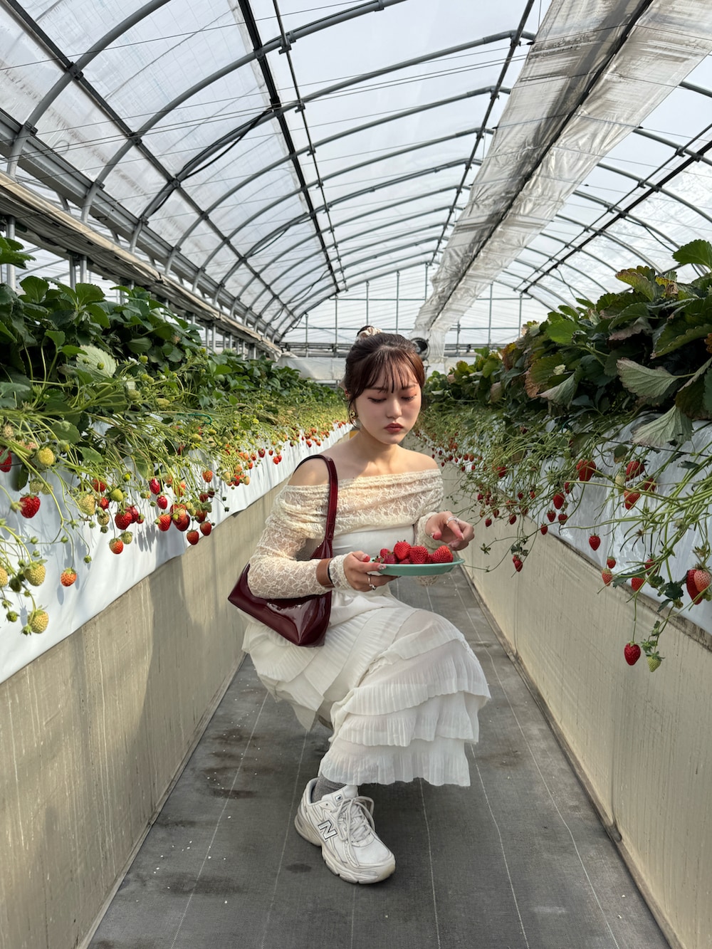 ホワイト系のTシャツ/カットソー、レッド系のハンドバッグ、ベージュ系のスカートを着用したレディースの春コーディネートの2枚目の写真