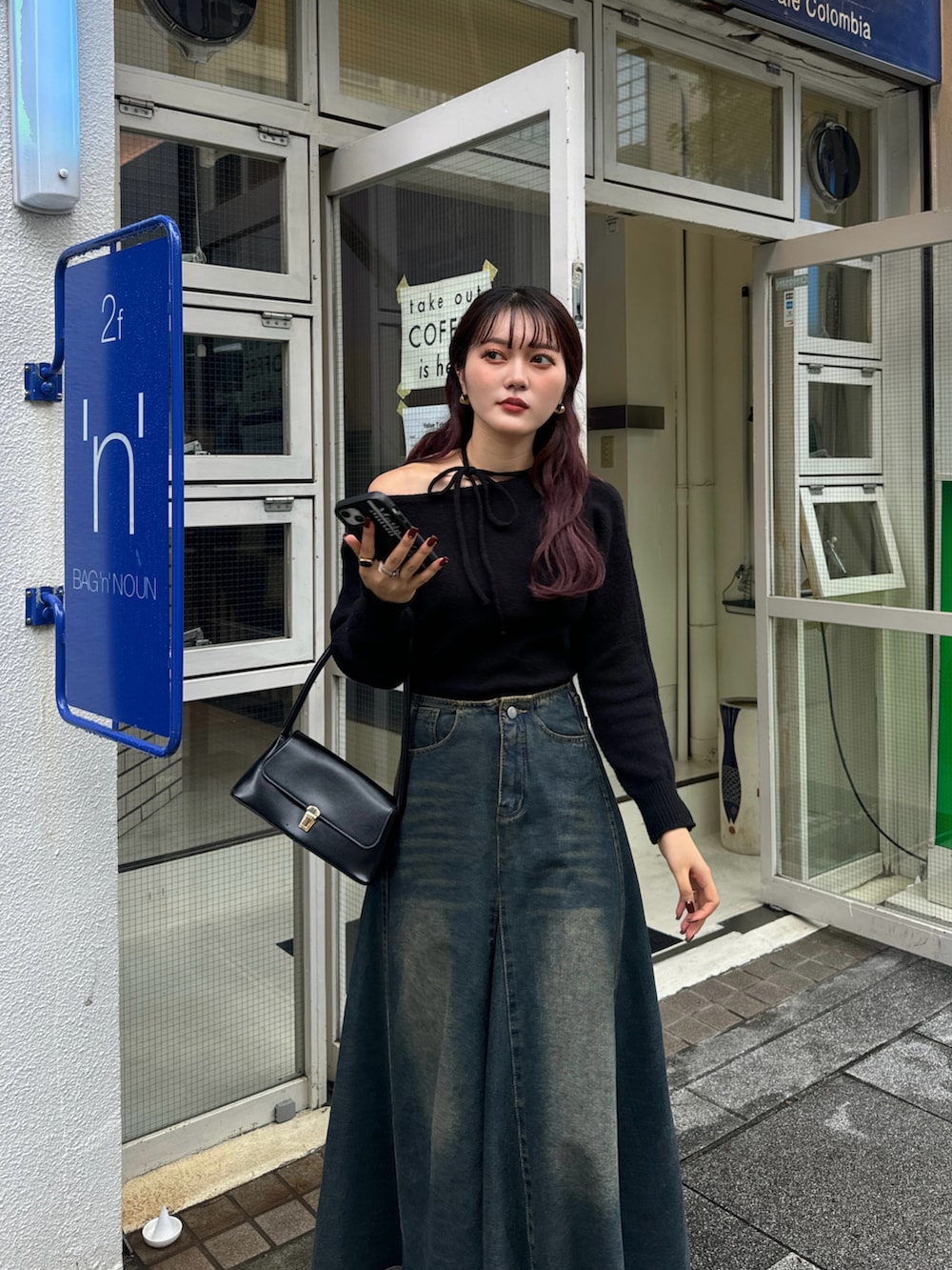 ブラック系のハンドバッグ、ブラック系のブーツを着用したレディースの秋コーディネートの5枚目の写真