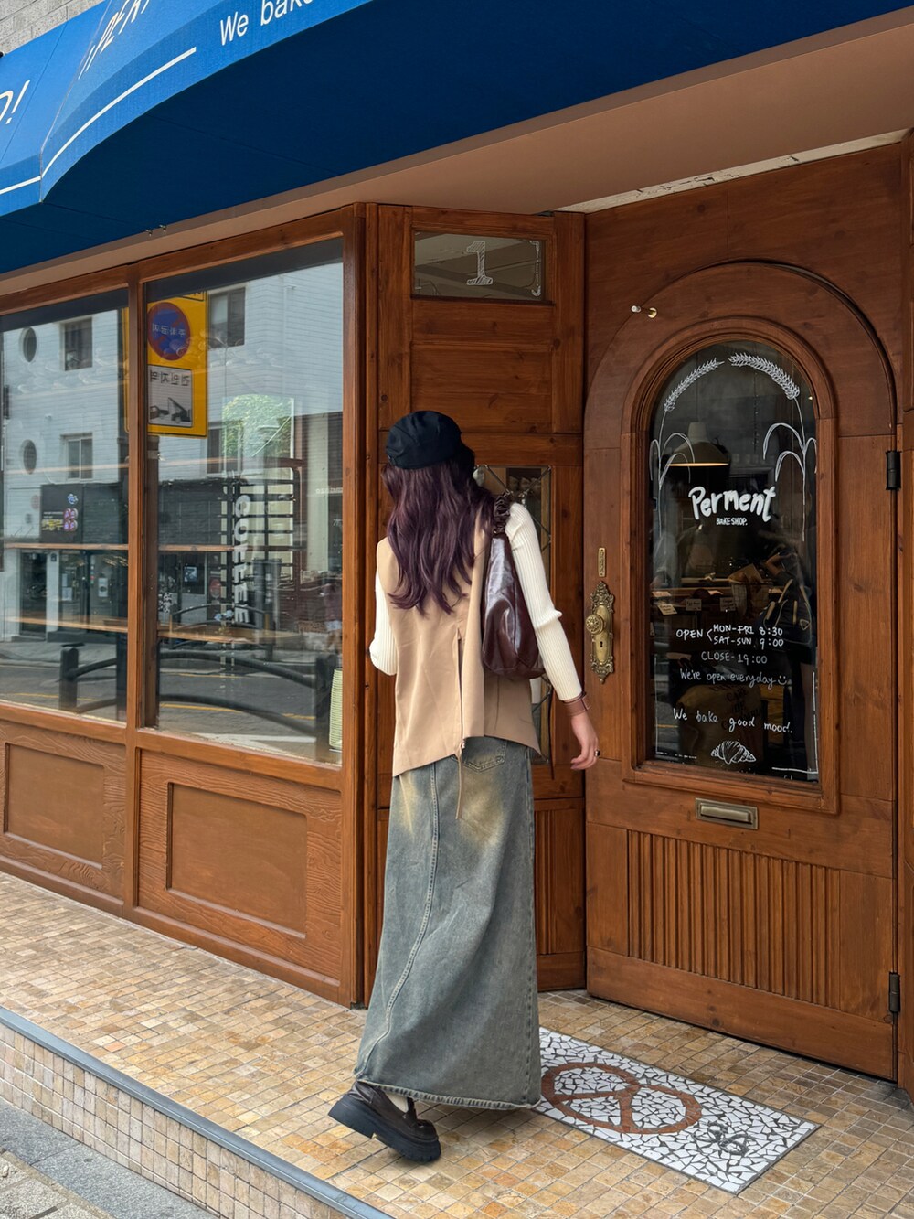 ブルー系のデニムスカート、ベージュ系のニット/セーター、ベージュ系のベストを着用したレディースの秋コーディネートの5枚目の写真