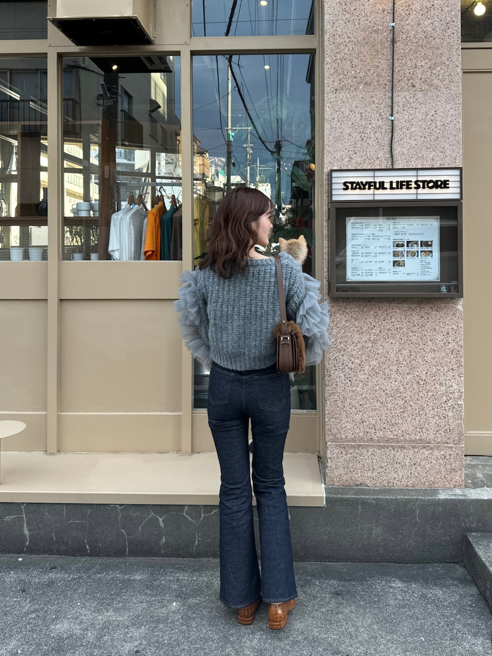 グレー系のニット/セーター、ブルー系のデニムパンツを着用したレディースの春コーディネートの5枚目の写真