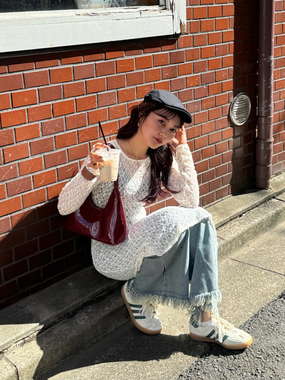 ベージュ系のワンピース、レッド系のハンドバッグ、ベージュ系のスニーカーを着用したレディースの秋コーディネートの5枚目の写真