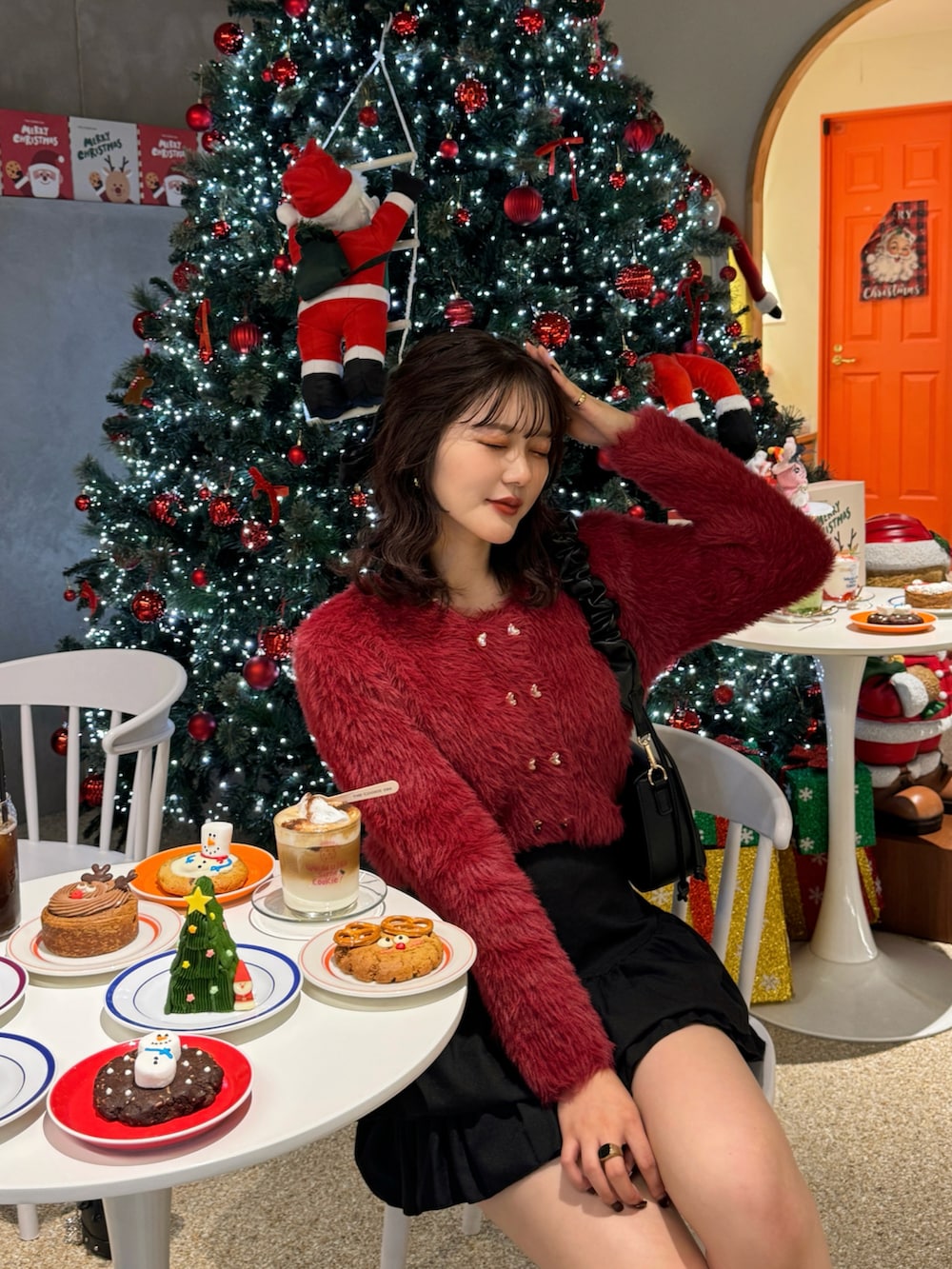 レッド系のカーディガン/ボレロ、ブラウン系のハンドバッグを着用したレディースの秋コーディネートの2枚目の写真