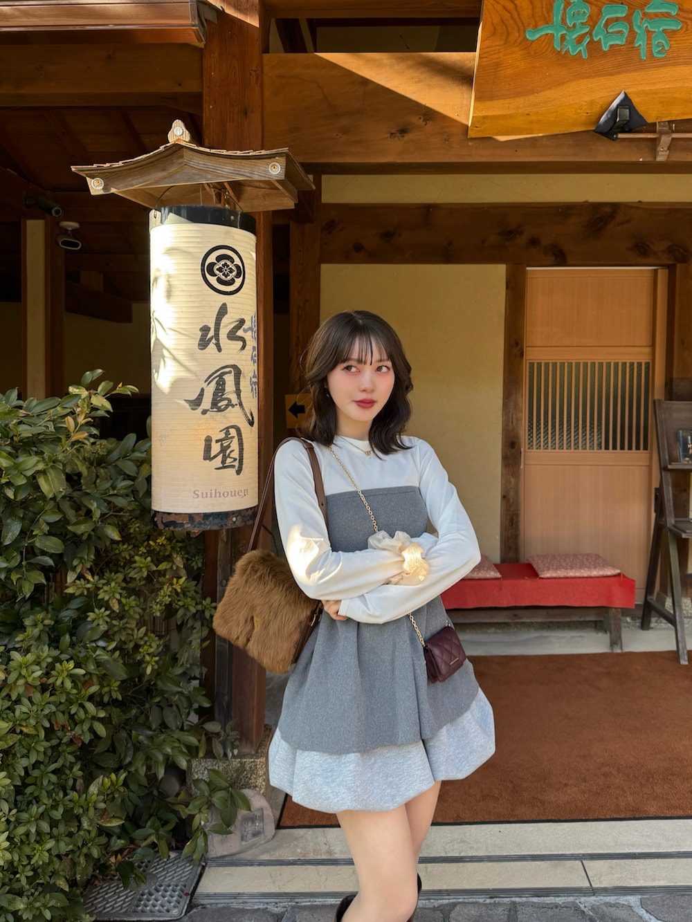 ブラウン系のブーツ、グレー系のスカートを着用したレディースの冬コーディネートの2枚目の写真