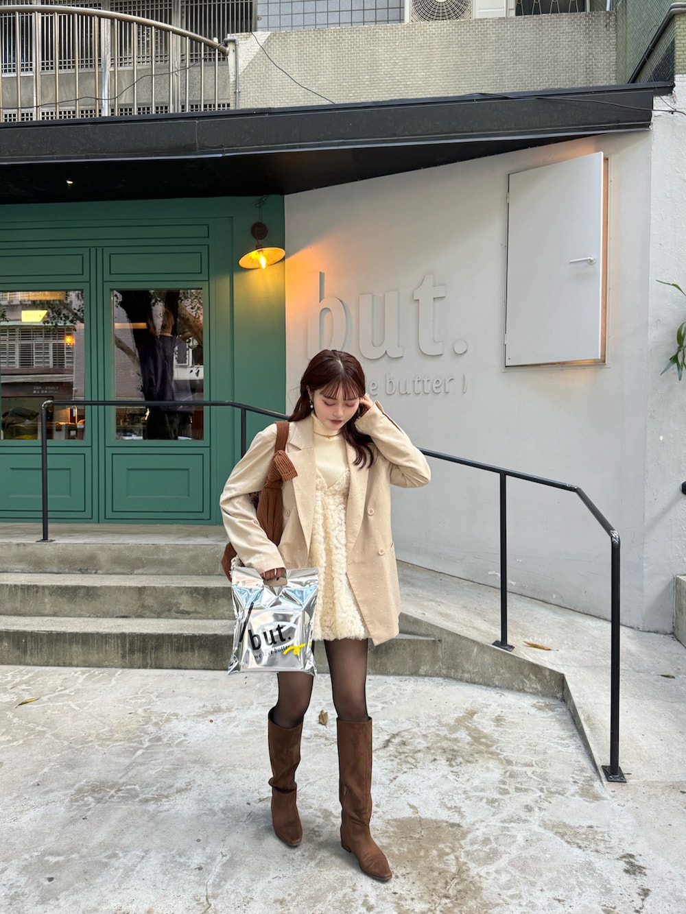 ベージュ系のテーラードジャケット、ブラウン系のブーツ、ブラック系のニット/セーターを着用したレディースの冬コーディネートの4枚目の写真