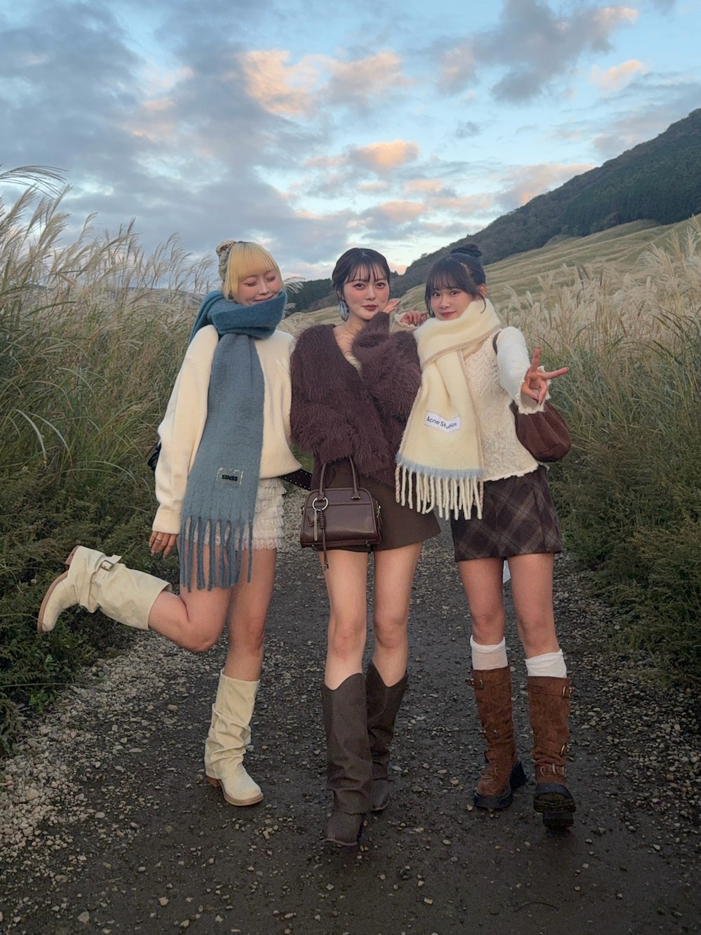 ブラウン系のボストンバッグ、ブラウン系のブーツを着用したレディースの秋コーディネートの2枚目の写真