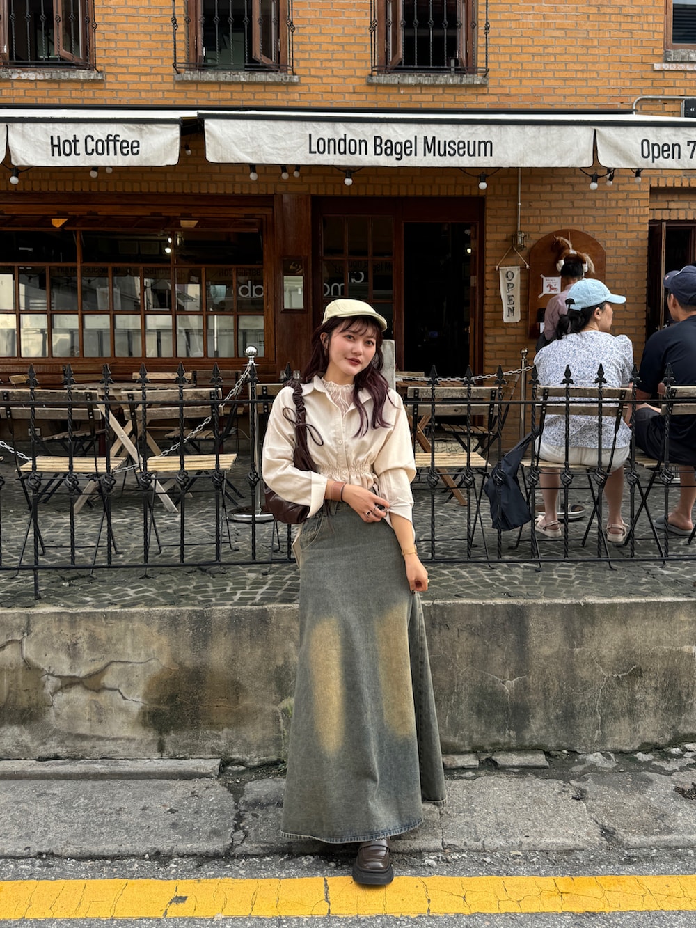 ベージュ系のシャツ/ブラウス、ブラウン系のハンドバッグ、ベージュ系のTシャツ/カットソーを着用したレディースの秋コーディネートの4枚目の写真