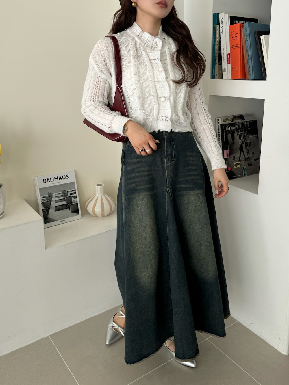 ブルー系のデニムパンツ、ホワイト系のカーディガン/ボレロを着用したレディースの冬コーディネートの4枚目の写真