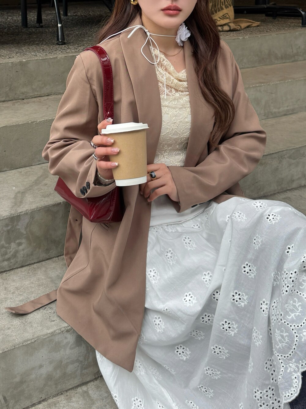 ブラウン系のテーラードジャケット、レッド系のハンドバッグ、ホワイト系のTシャツ/カットソーを着用したレディースの春コーディネートの3枚目の写真