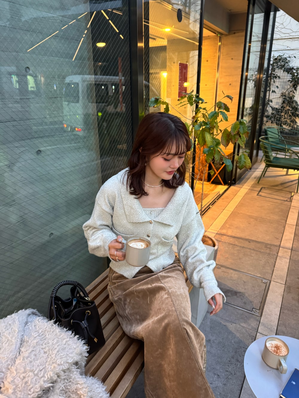 ホワイト系のその他アウター、ホワイト系のカーディガン/ボレロ、ブラウン系のブーツを着用したレディースの冬コーディネートの2枚目の写真