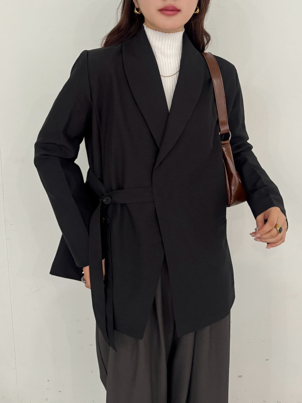 ブラウン系のテーラードジャケット、ホワイト系のTシャツ/カットソー、レッド系のショルダーバッグを着用したレディースの春コーディネートの4枚目の写真