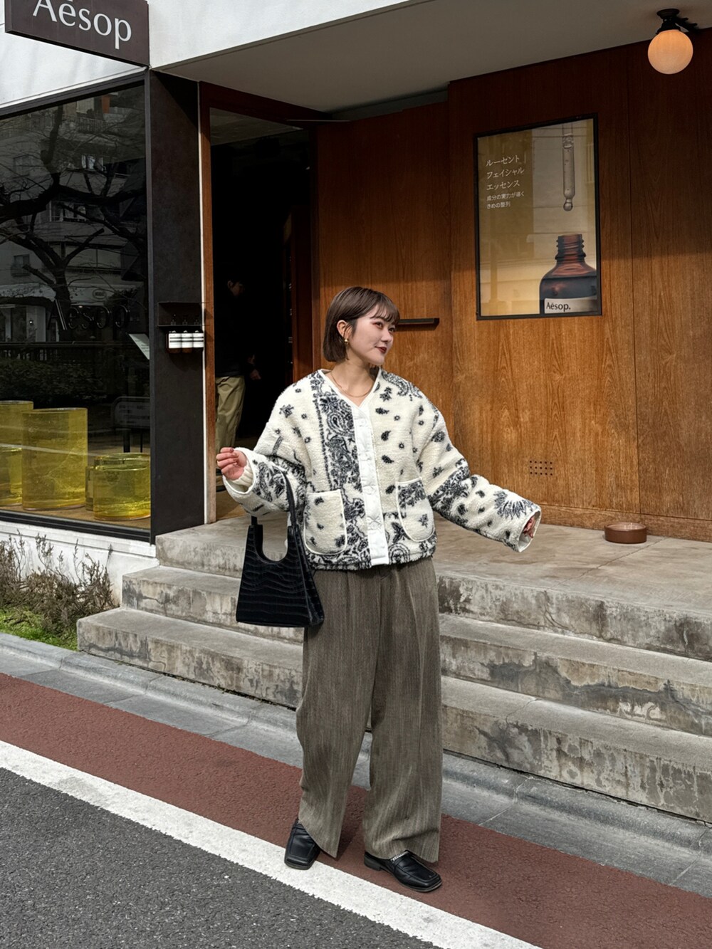 ブラウン系のパンツ、ホワイト系のタンクトップを着用したレディースの冬コーディネートの3枚目の写真