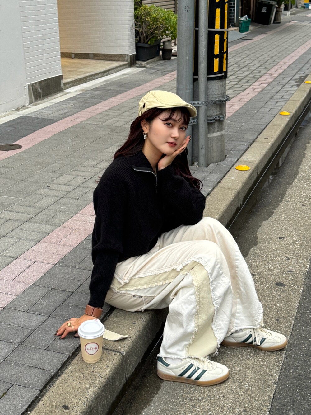 ブラック系のニット/セーター、ホワイト系のデニムパンツ、ベージュ系のスニーカーを着用したレディースの秋コーディネートの2枚目の写真