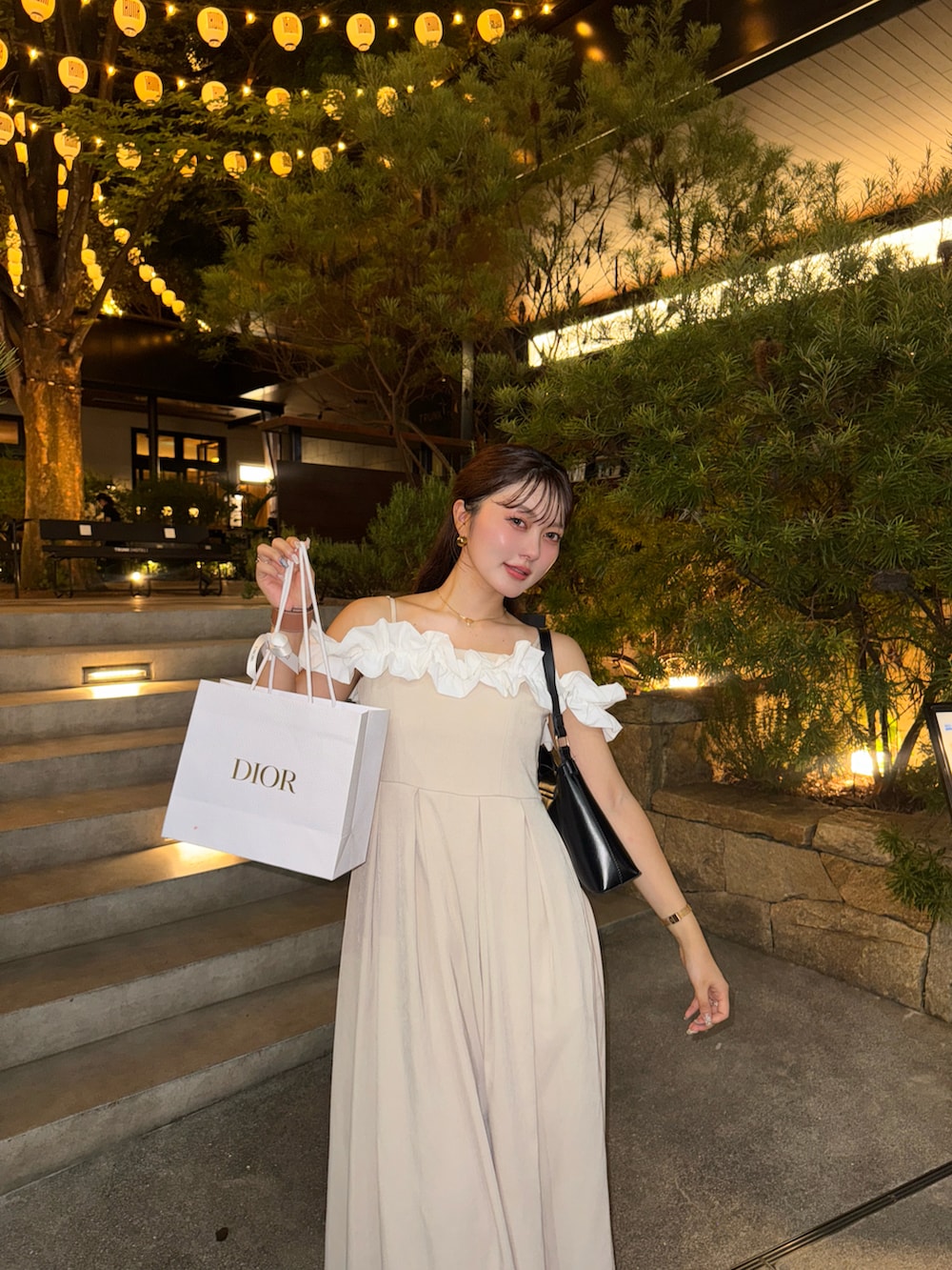 ブラック系のドレス、ブラウン系のサンダル、ブラック系のハンドバッグを着用したレディースの夏コーディネートの3枚目の写真