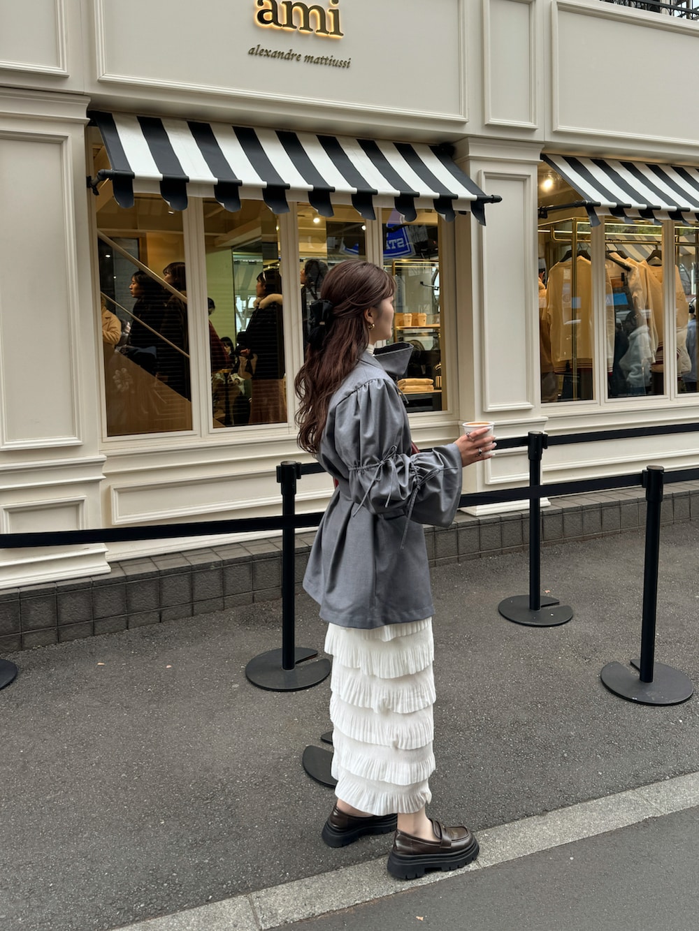 グレー系のテーラードジャケット、レッド系のショルダーバッグを着用したレディースの冬コーディネートの2枚目の写真