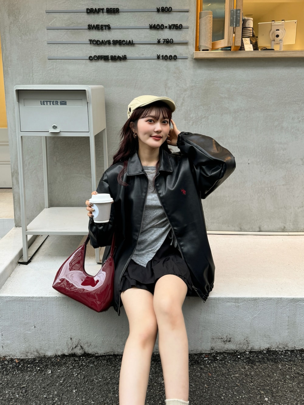 レッド系のハンドバッグ、グレー系のTシャツ/カットソー、ブラック系のジャケット/アウターを着用したレディースの秋コーディネートの5枚目の写真