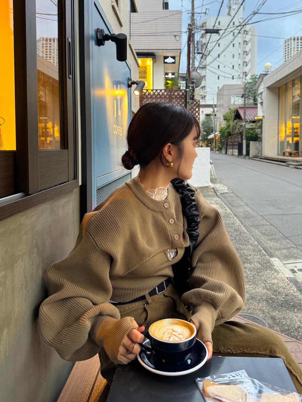 ホワイト系のカーディガン/ボレロ、ブラウン系のハンドバッグを着用したレディースの秋コーディネートの4枚目の写真