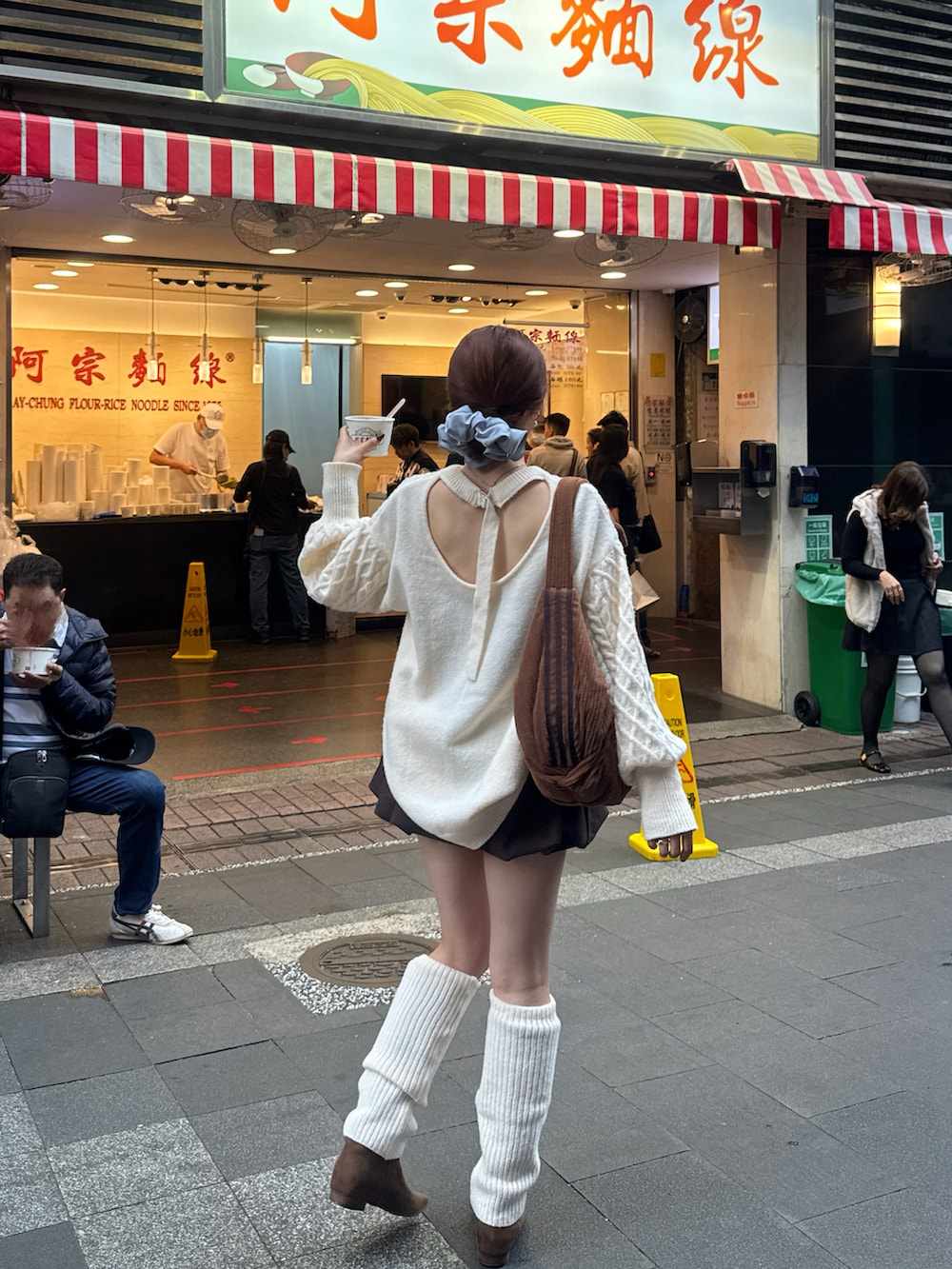 ブラウン系のブーツ、ブラウン系のスカート、ホワイト系のニット/セーターを着用したレディースの冬コーディネートの2枚目の写真