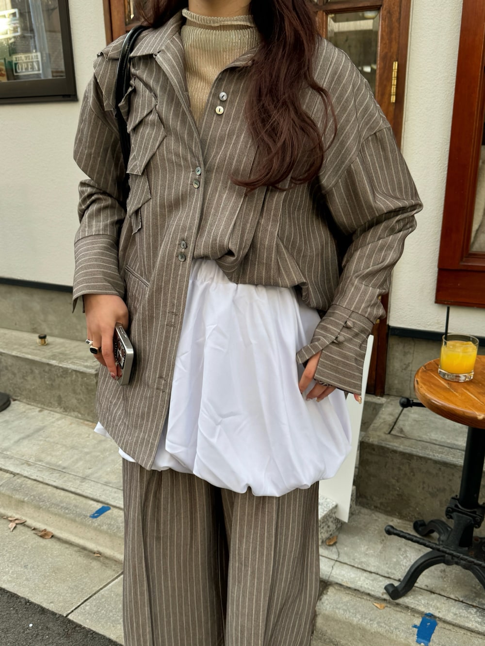 ブラウン系のシャツ/ブラウス、ブラウン系のその他パンツ、ホワイト系のスカートを着用したレディースの冬コーディネートの5枚目の写真