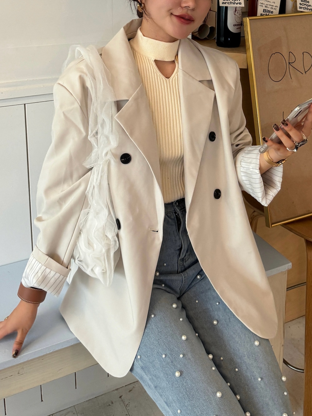 ホワイト系のテーラードジャケット、ブルー系のデニムパンツ、ホワイト系のハンドバッグを着用したレディースの秋コーディネートの5枚目の写真