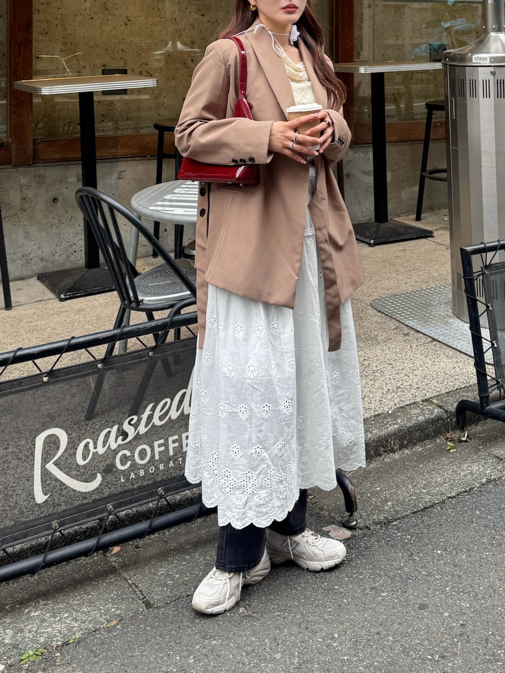 ブラウン系のテーラードジャケット、レッド系のハンドバッグ、ホワイト系のTシャツ/カットソーを着用したレディースの春コーディネートの2枚目の写真