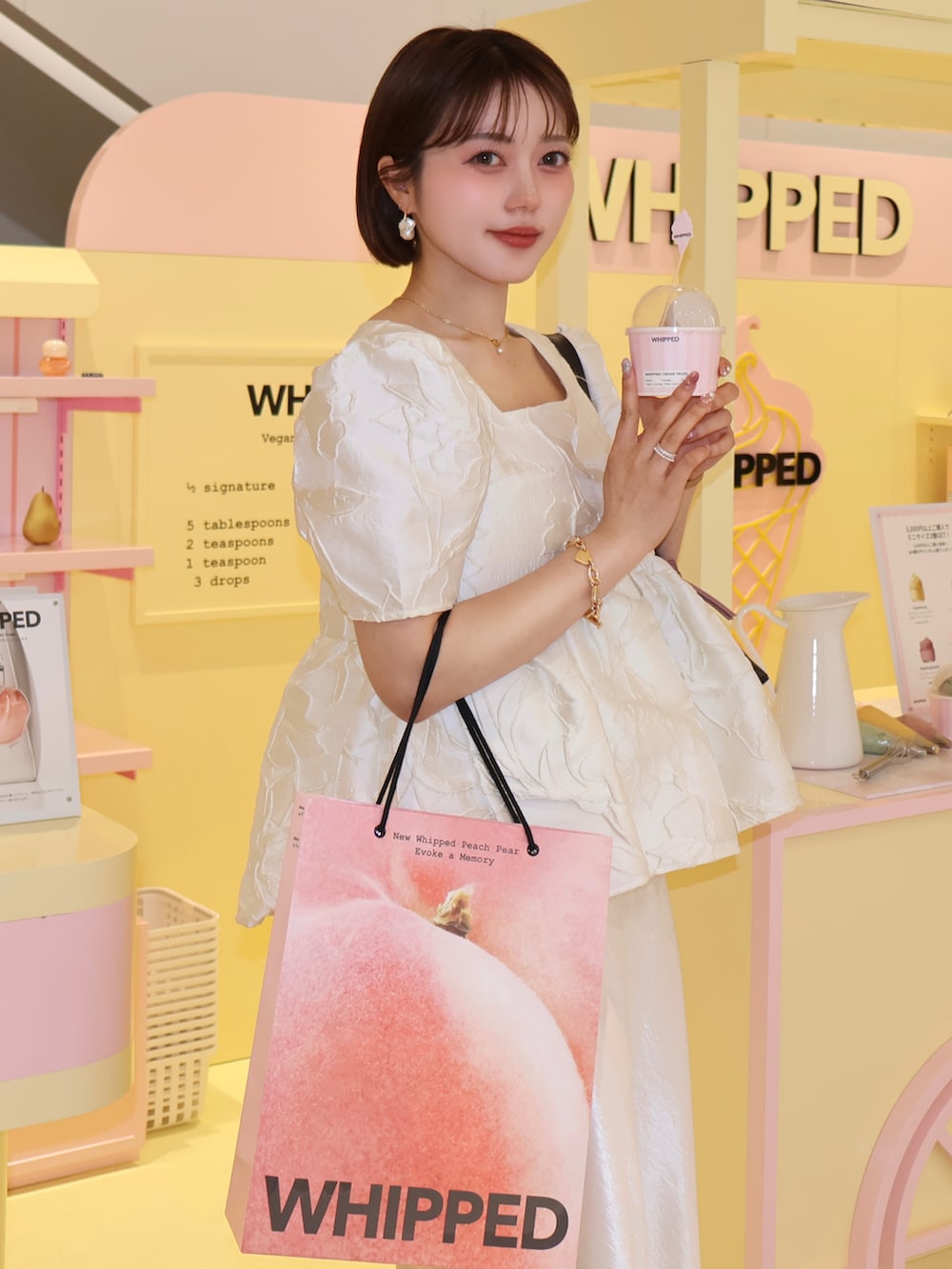 ホワイト系のシャツ/ブラウス、ホワイト系のスカート、ブラック系のパンプスを着用したレディースの夏コーディネートの3枚目の写真