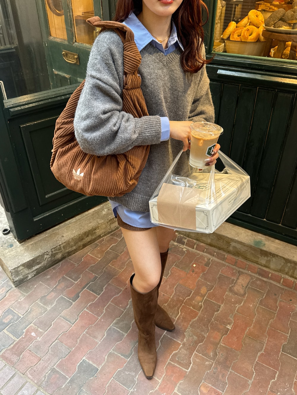 グレー系のニット/セーター、ブルー系のシャツ/ブラウス、ブラウン系のブーツを着用したレディースの秋コーディネートの4枚目の写真