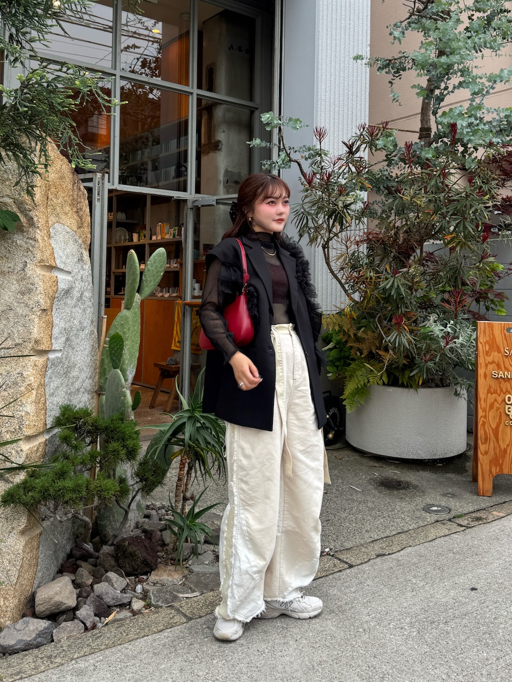 ホワイト系のデニムパンツ、ベージュ系のスニーカー、ブラック系のTシャツ/カットソーを着用したレディースの春コーディネートの2枚目の写真