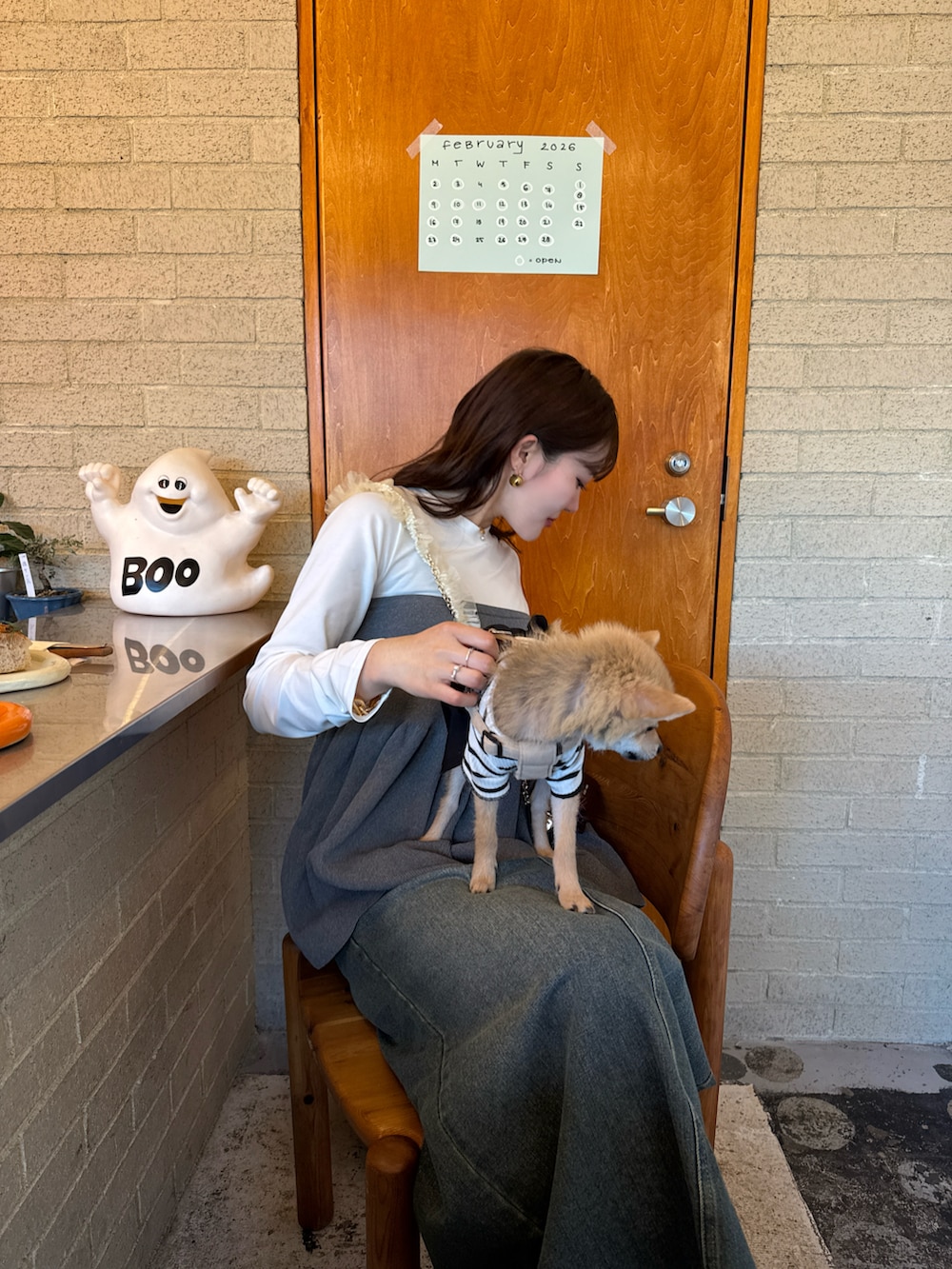 グレー系のトップス、ブルー系のデニムスカート、ブラウン系のスニーカーを着用したレディースの冬コーディネートの5枚目の写真