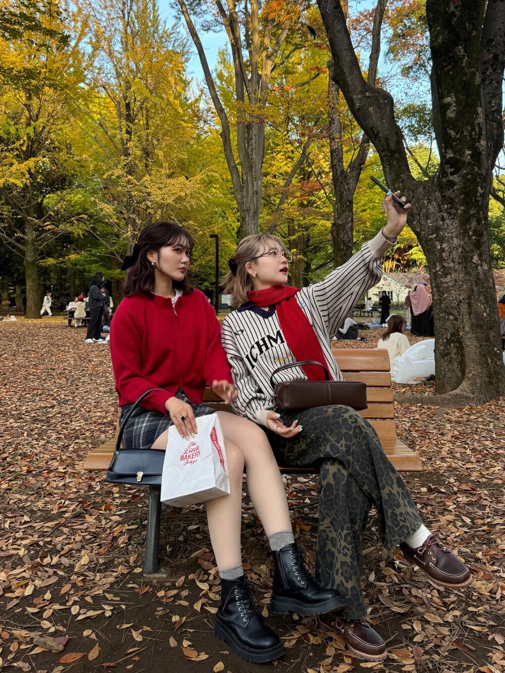 ブラック系のブーツ、ブラック系のハンドバッグを着用したレディースの秋コーディネートの2枚目の写真