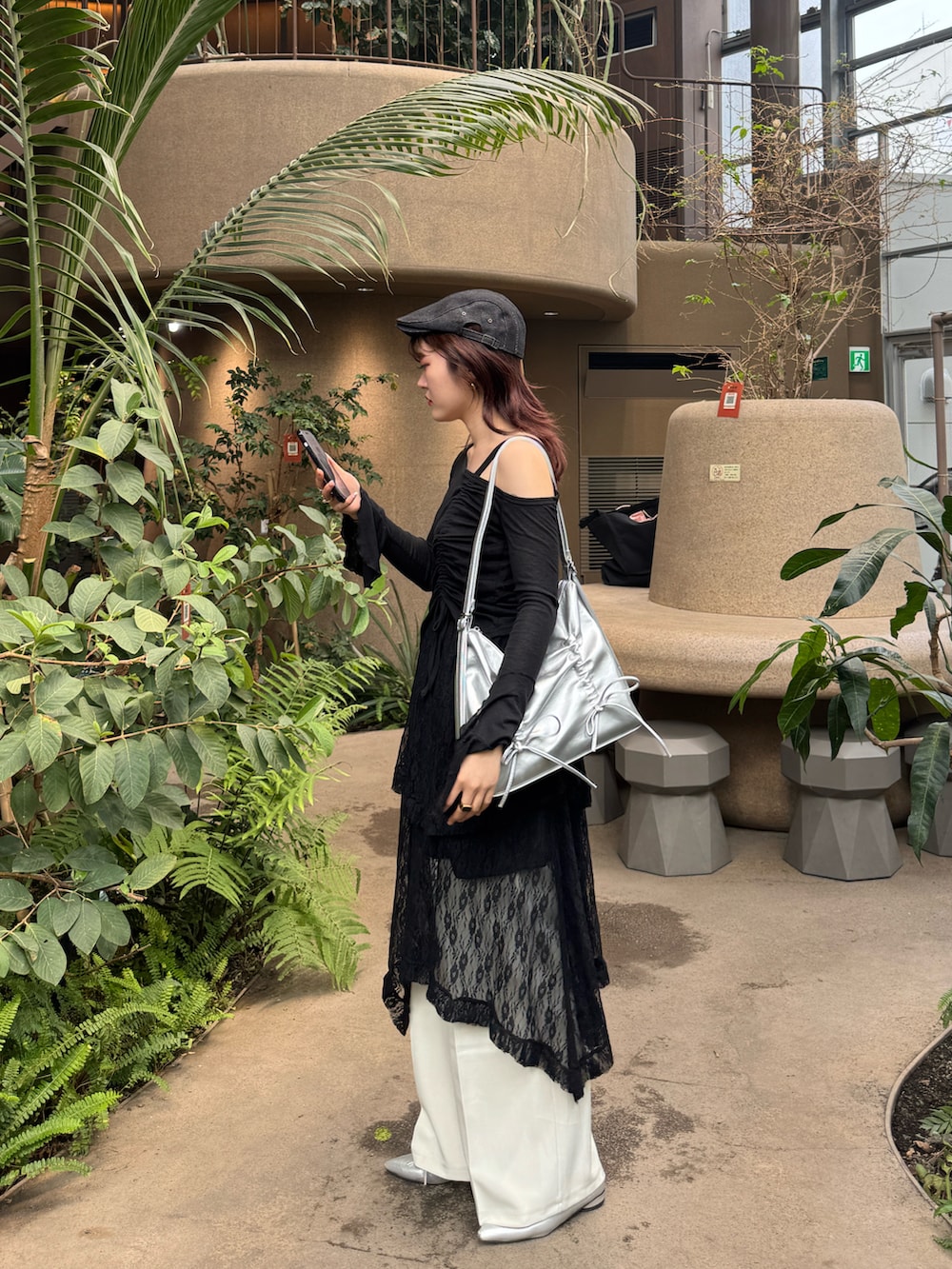 ブラック系のTシャツ/カットソー、ブラック系のスカート、シルバー系のショルダーバッグを着用したレディースの春コーディネートの3枚目の写真