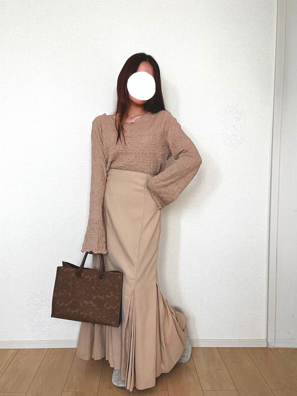 ベージュ系のスカート、ブラウン系のトートバッグ、ベージュ系のTシャツ/カットソーを着用したレディースの秋コーディネートの2枚目の写真