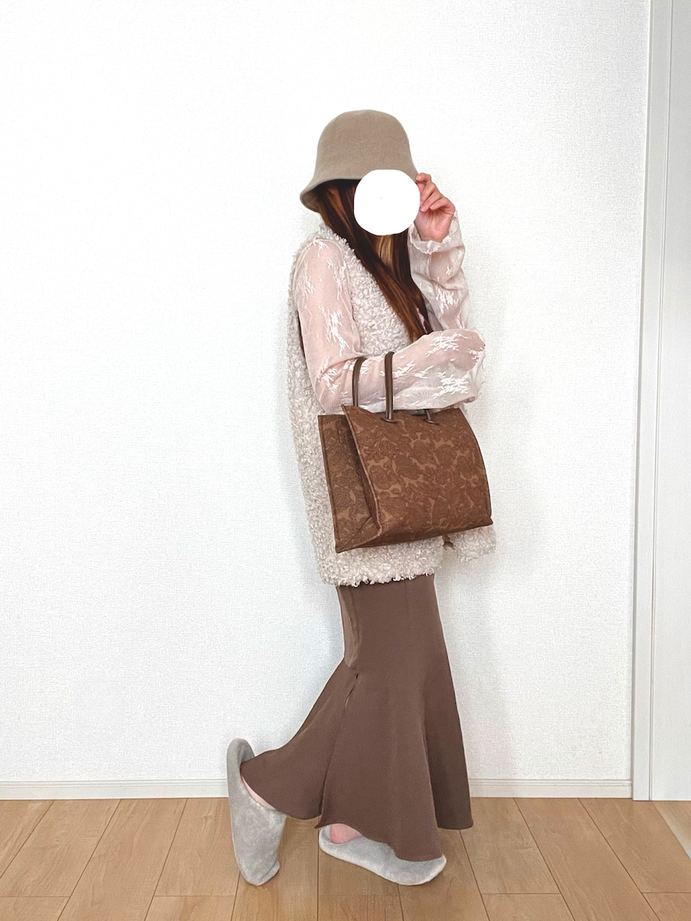 ホワイト系のベスト、ホワイト系のTシャツ/カットソー、ブラウン系のスカートを着用したレディースの秋コーディネートの2枚目の写真