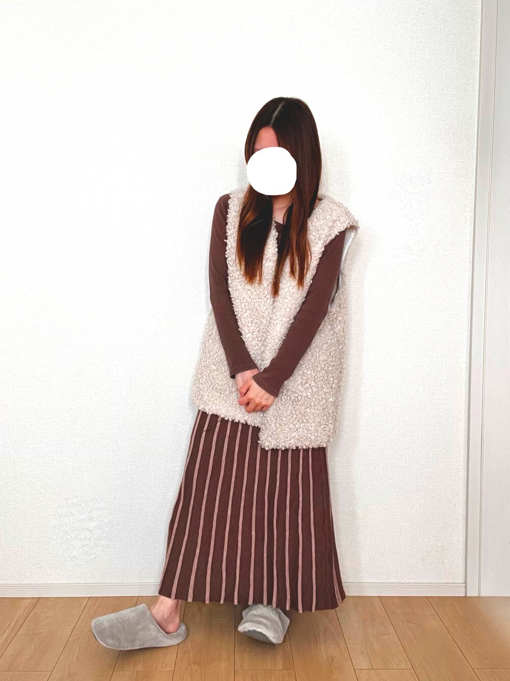 ホワイト系のベスト、ブラウン系のスカートを着用したレディースの秋コーディネートの3枚目の写真