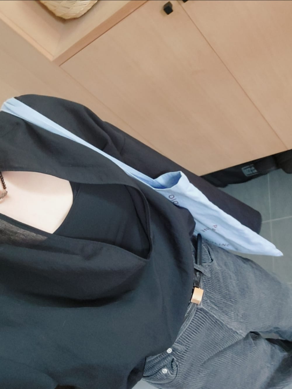 グレー系のチノパンツ、ブラック系のシャツ/ブラウス、ブルー系のトートバッグを着用したレディースの秋コーディネートの2枚目の写真