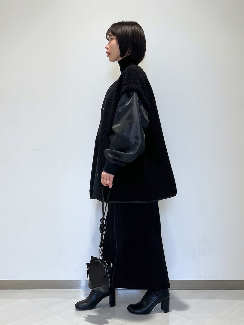 ブラック系のスカート、ブラック系のブルゾン、ブラック系のブーツを着用したレディースの冬コーディネートの2枚目の写真
