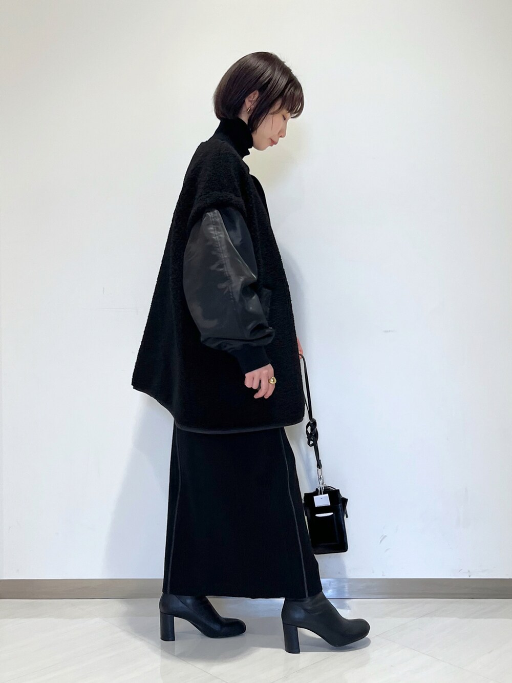 ブラック系のスカート、ブラック系のブルゾン、ブラック系のブーツを着用したレディースの冬コーディネートの4枚目の写真