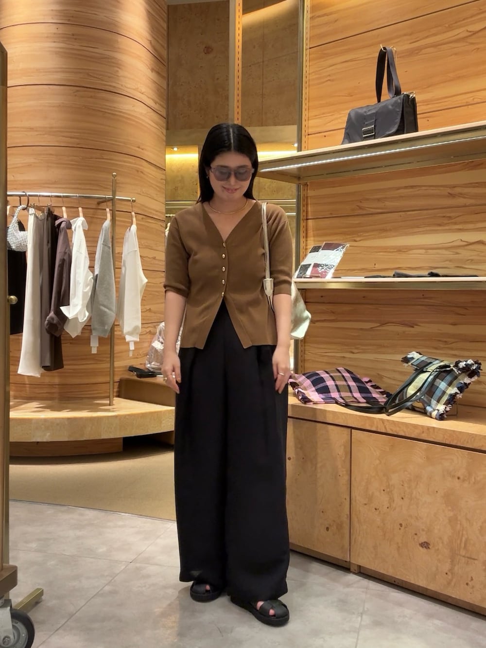 ブラウン系のカーディガン/ボレロ、ブラック系のその他パンツ、ブラック系のサンダルを着用したレディースの春コーディネートの2枚目の写真