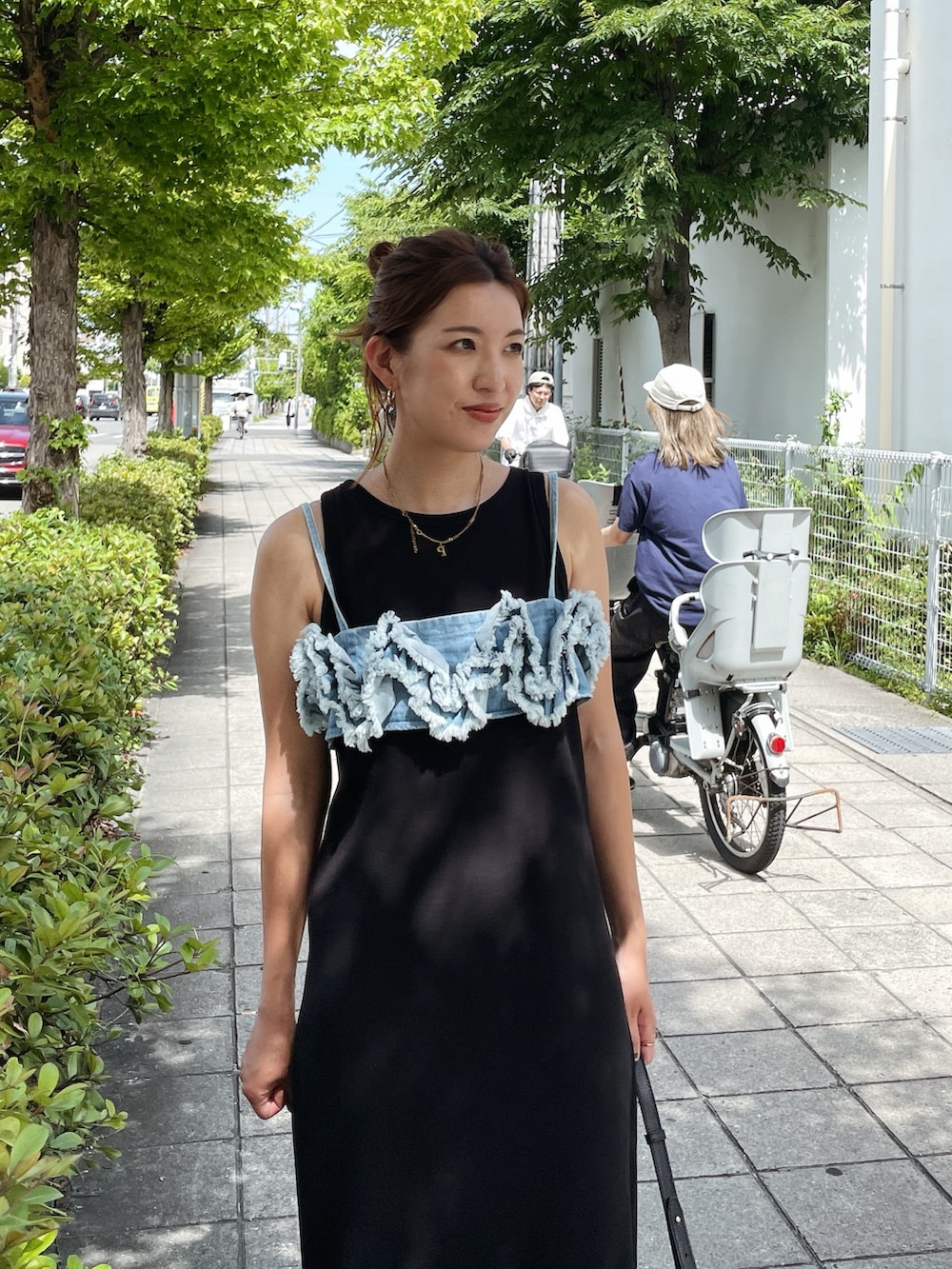 ブラック系のワンピース、ブルー系のキャミソール、ブラック系のサンダルを着用したレディースの夏コーディネートの3枚目の写真