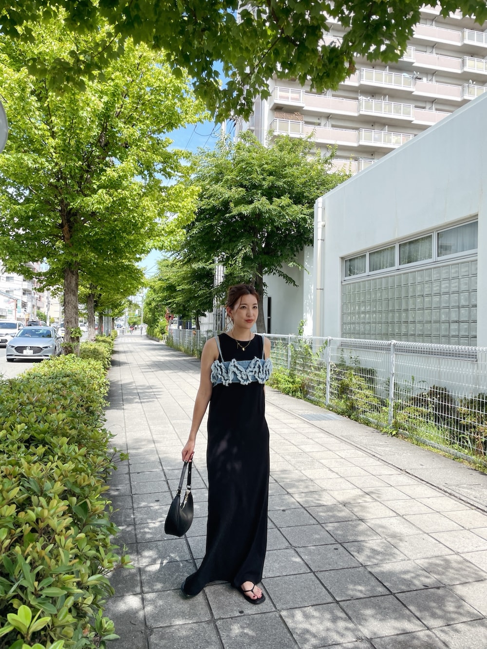 ブラック系のワンピース、ブルー系のキャミソール、ブラック系のサンダルを着用したレディースの夏コーディネートの2枚目の写真