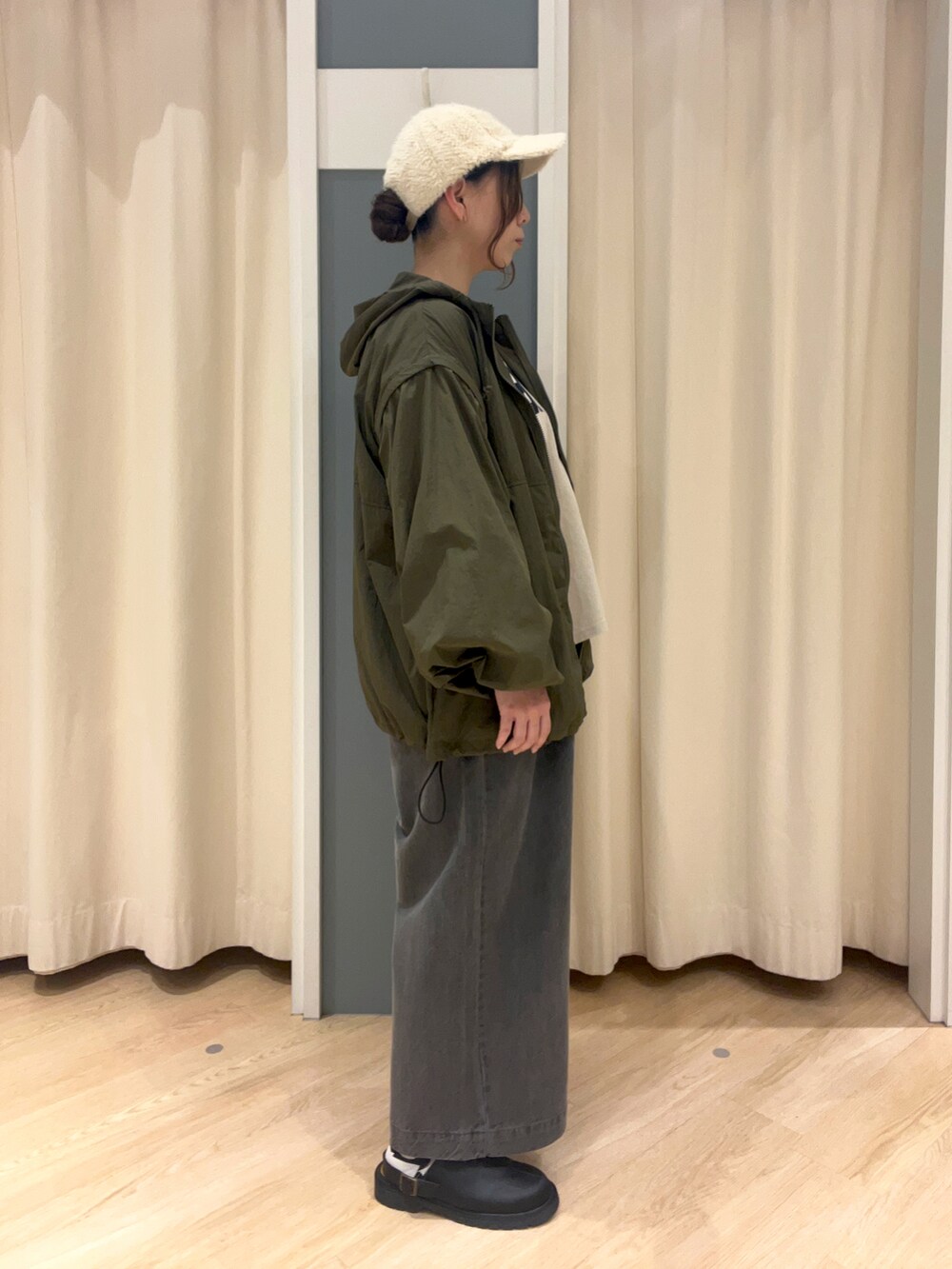 グレー系のデニムパンツ、ベージュ系のTシャツ/カットソー、グリーン系のブルゾンを着用したレディースの秋コーディネートの3枚目の写真