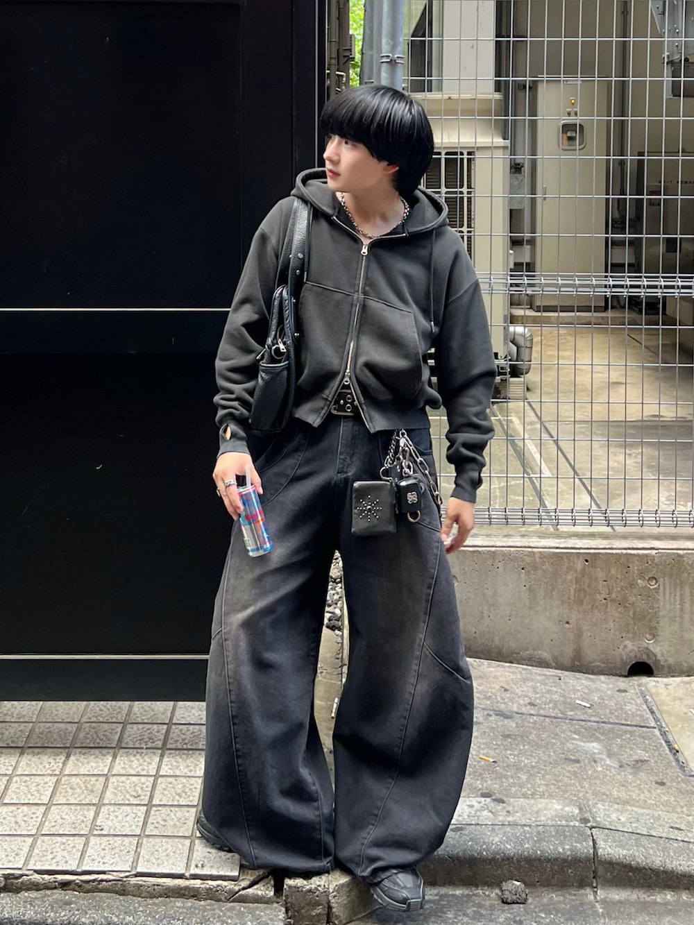 ブラック系のパーカー、ブラック系のデニムパンツ、ブラック系のショルダーバッグを着用したメンズの秋コーディネートの2枚目の写真