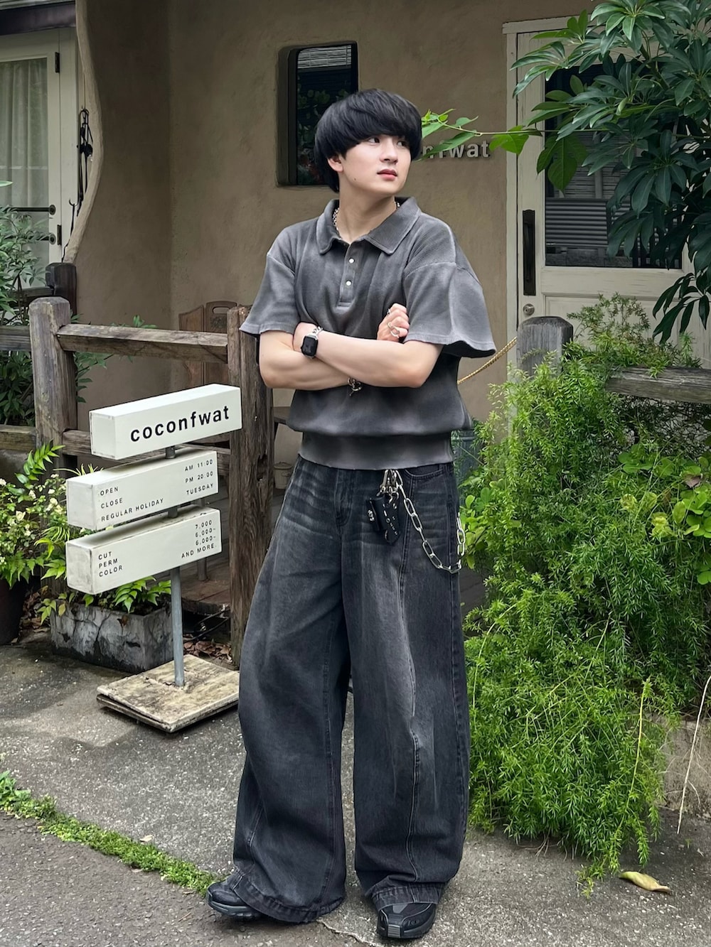 グレー系のポロシャツ、ブラック系のデニムパンツ、ブラック系のスニーカーを着用したメンズの夏コーディネートの2枚目の写真