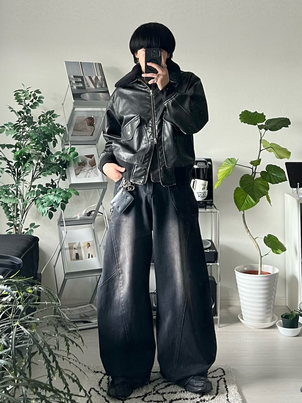 ブラック系のデニムパンツ、ブラック系のショルダーバッグ、ブラック系のブルゾンを着用したメンズの秋コーディネートの3枚目の写真