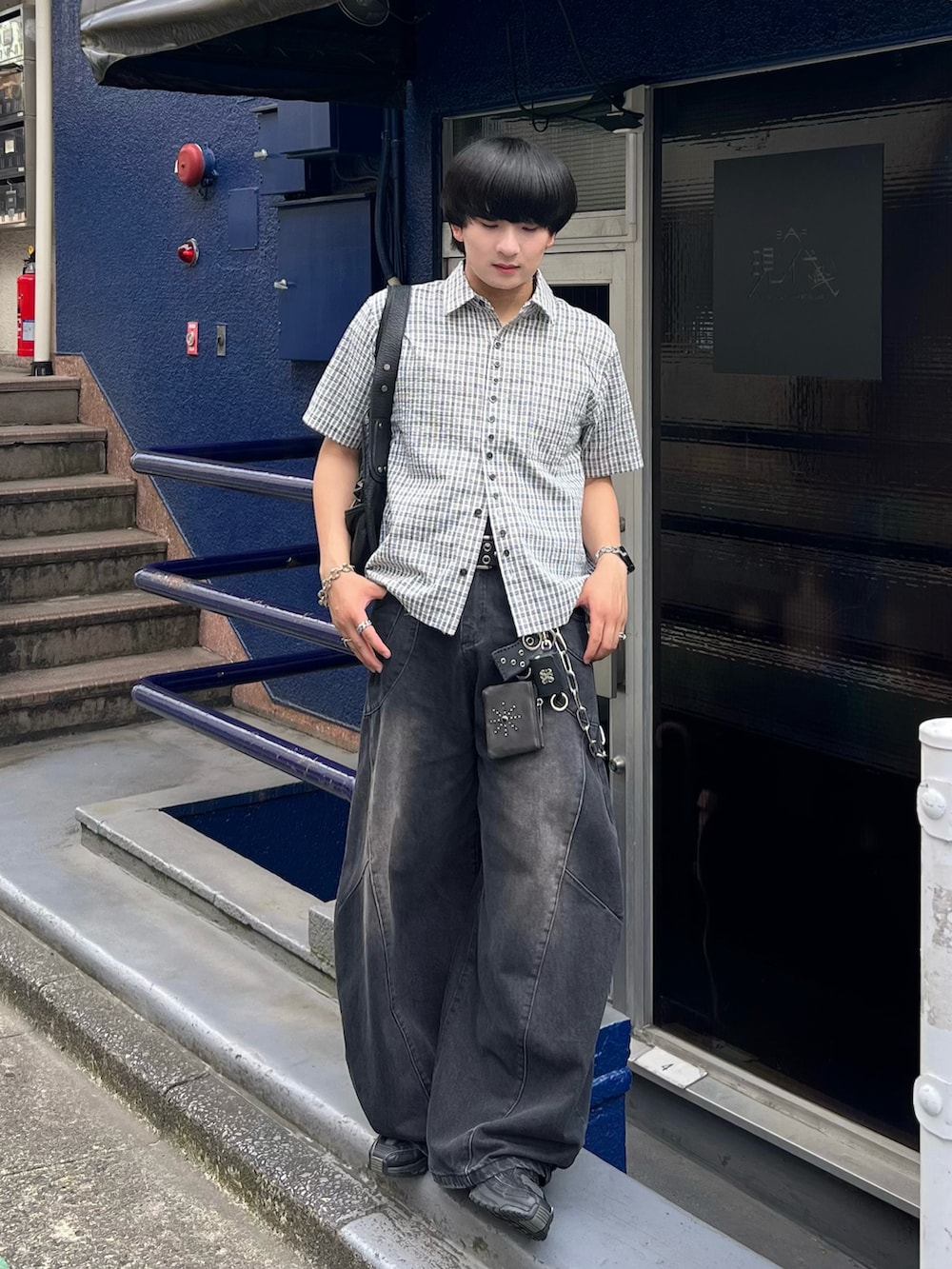 ブラック系のデニムパンツ、ブルー系のシャツ/ブラウス、ブラック系のショルダーバッグを着用したメンズの夏コーディネートの3枚目の写真