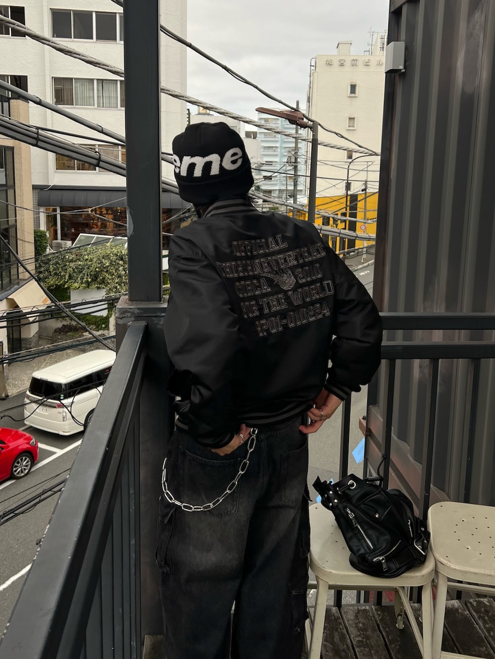 ブラック系のブルゾン、ブラック系のショルダーバッグ、ブラック系のデニムパンツを着用したメンズの秋コーディネートの3枚目の写真