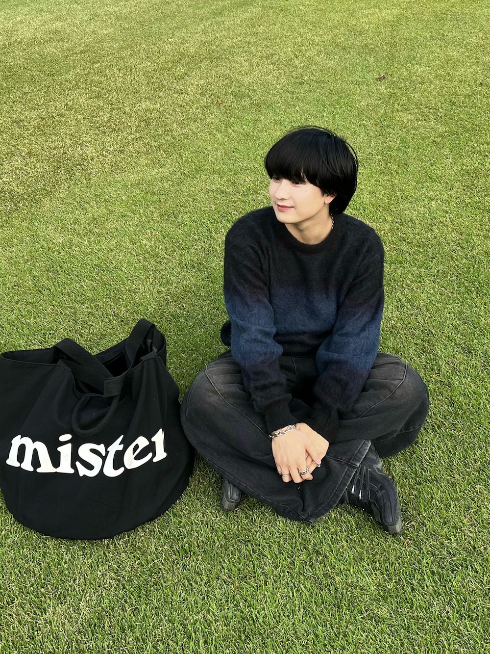 ブラック系のニット/セーター、ブラック系のデニムパンツ、ブラック系のスニーカーを着用したメンズの秋コーディネートの2枚目の写真