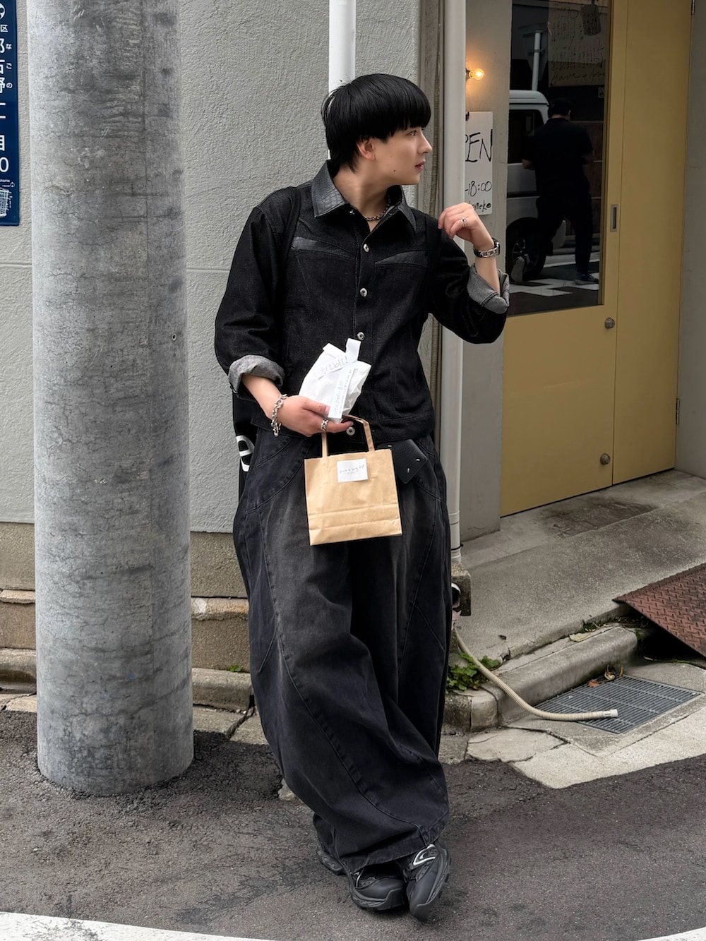 ブラック系のデニムパンツ、ブラック系のスニーカー、ブラック系のデニムジャケットを着用したメンズの春コーディネートの3枚目の写真